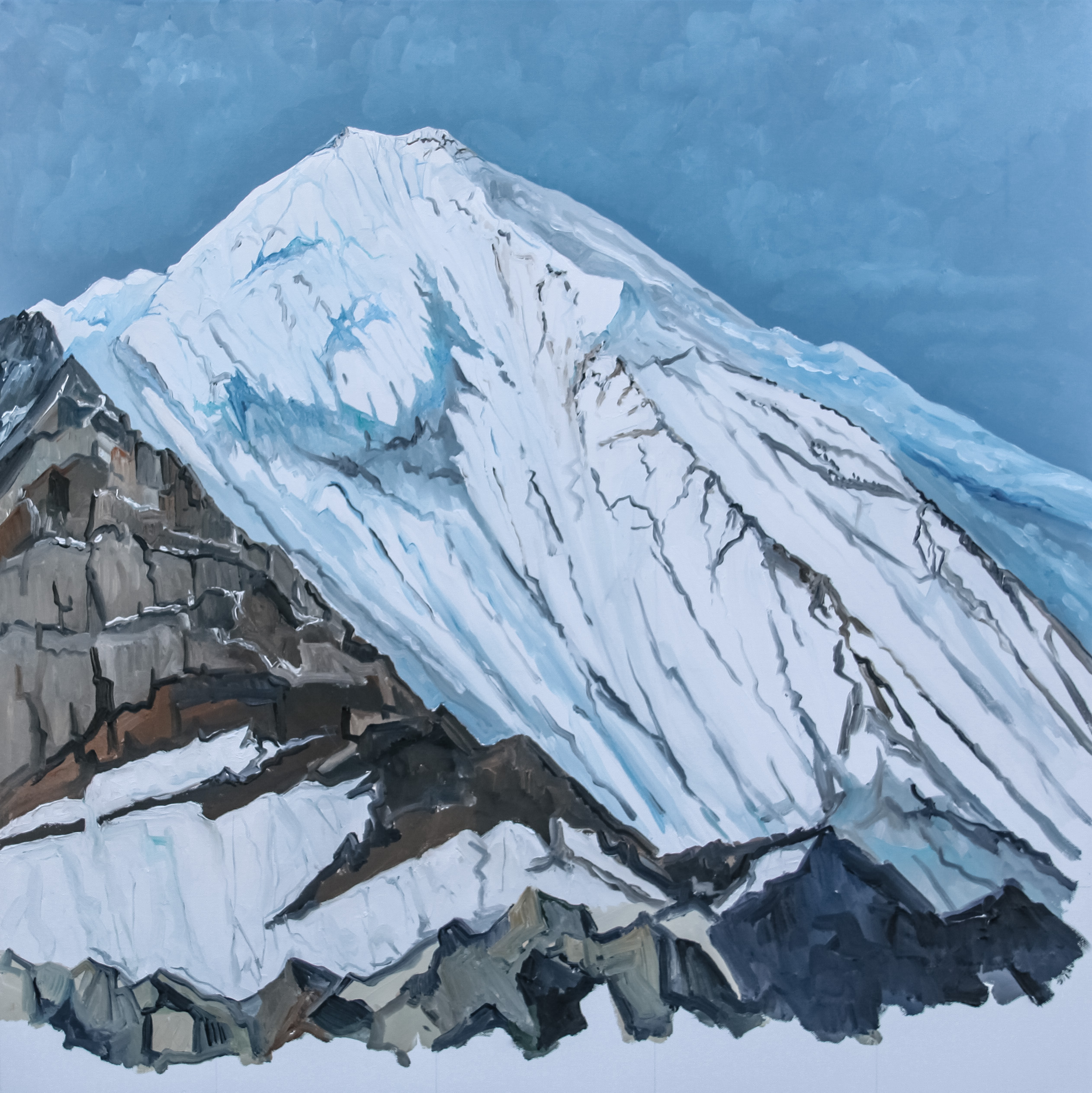 Snow-covered mountain peak with steep, jagged slopes under a blue sky.